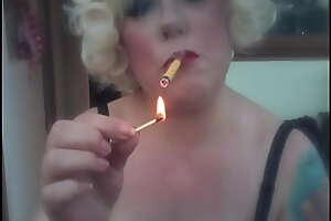 A Blonde Retro Mistress Smoking A Yellow Sobranie Cloud over With Match Phosphorescence